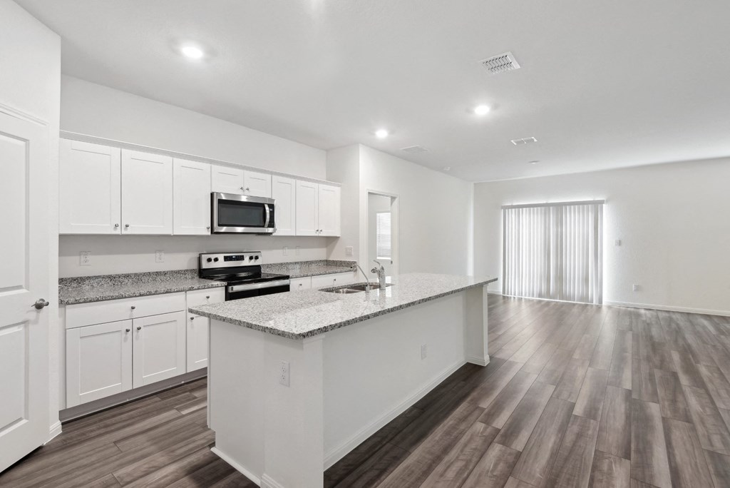 kitchen with marble countertop and white cabinets within a spacious living area