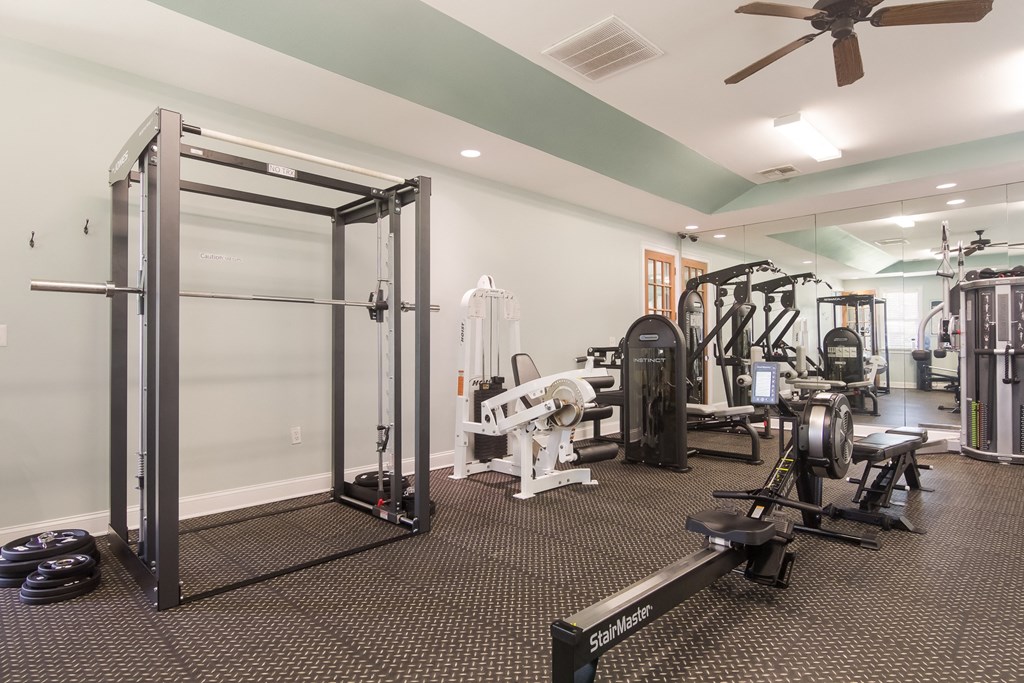 a gym with weights and cardio equipment and a glass door