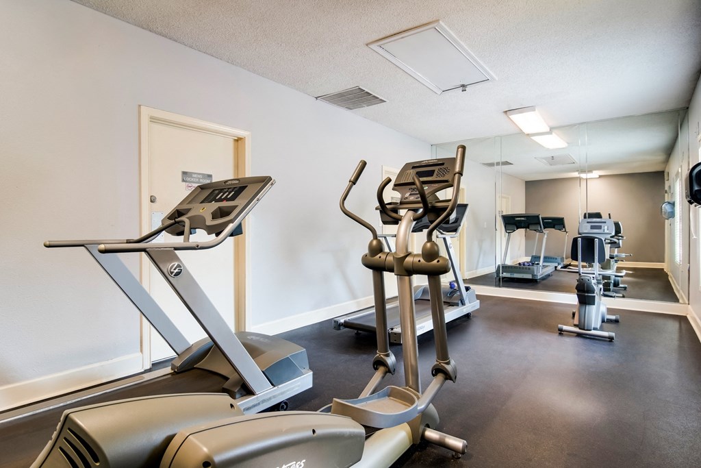 the gym with treadmills and other exercise equipment at the apartments