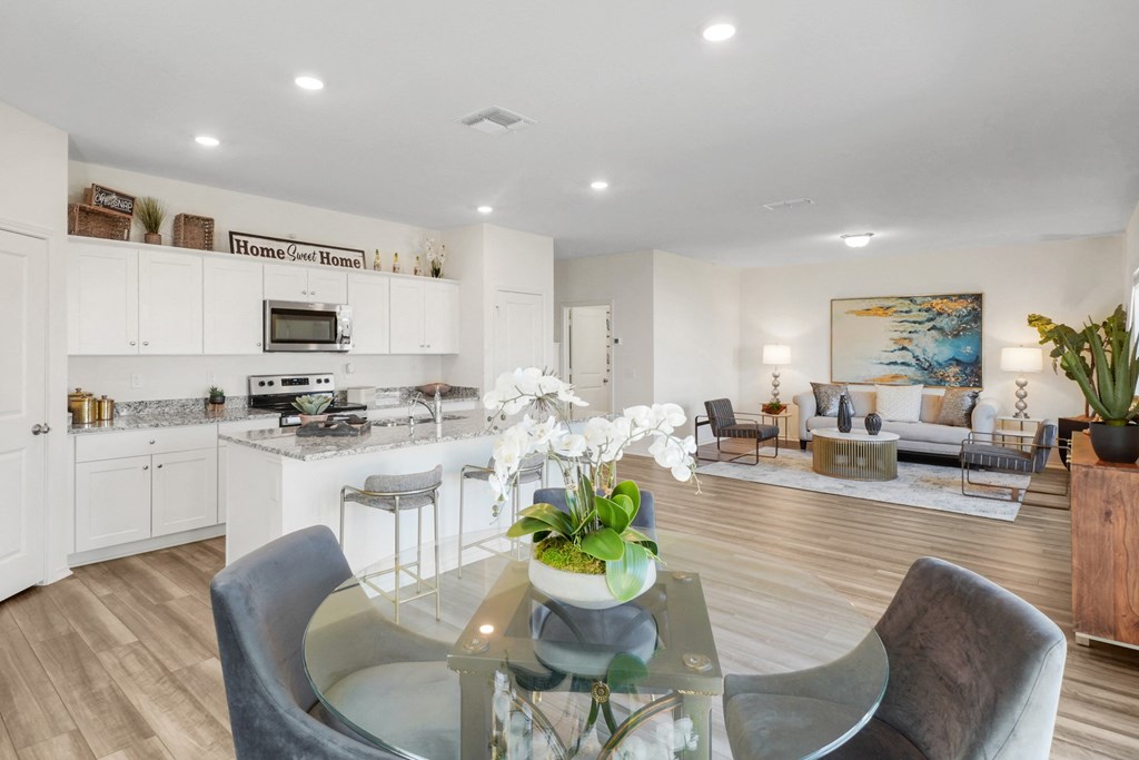 a living room and kitchen area with a glass table and chairsat Beacon at Meridian, San Antonio Texas