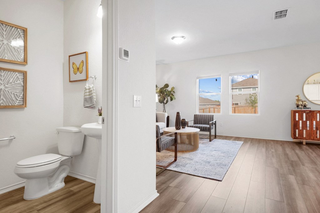 a bathroom with a toilet and a sink in a room with a couch and chair at Beacon at Meridian, San Antonio, 29485