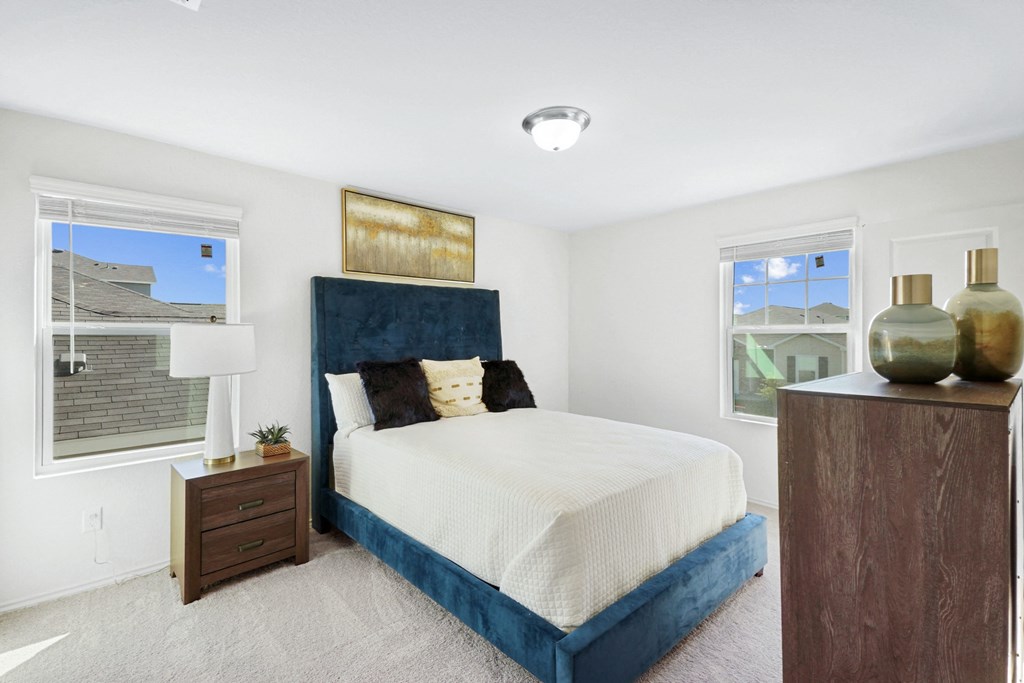 a bedroom with a bed and two windows at Beacon at Meridian, San Antonio, TX