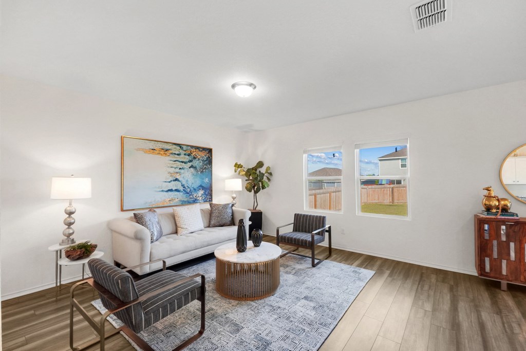 a living room with white walls and hardwood floors at Beacon at Meridian, Texas