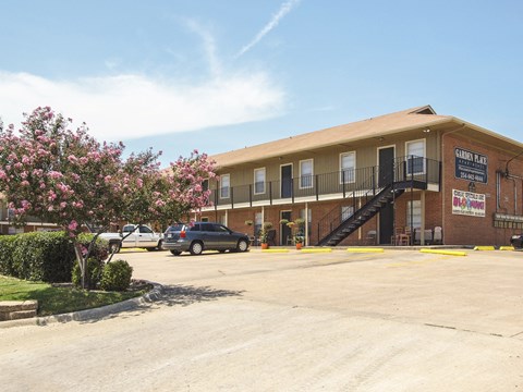 A building with a sign that says "Buddy's Place" is surrounded by a parking lot.
