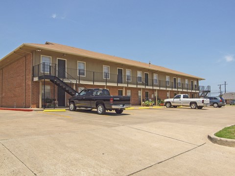 A black truck is parked in front of a building with a yellow line.