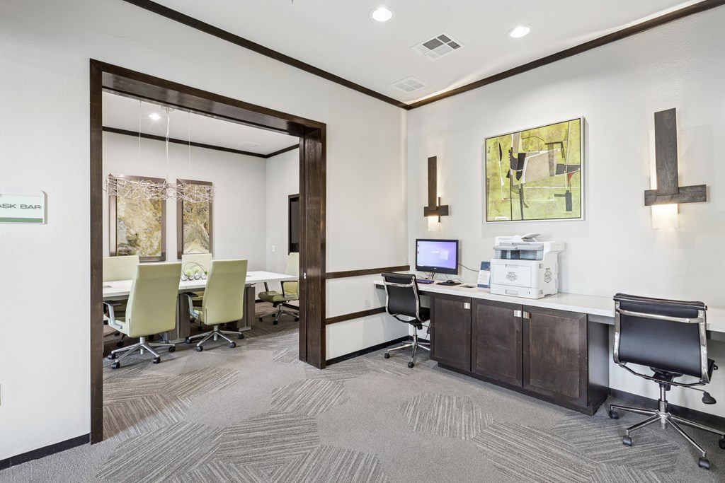 A business center with a computer, printer, and conference room at GreenVue Apartments in Richardson, TX