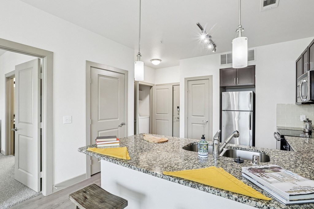 A kitchen with granite countertops and stainless steel appliances at GreenVue Apartments in Richardson, TX