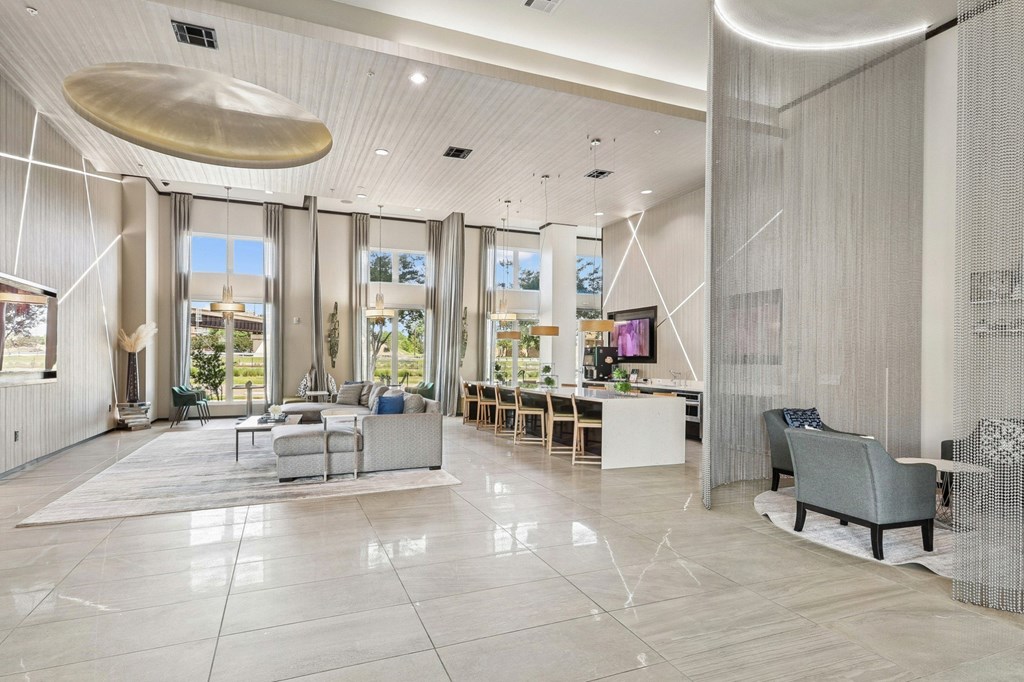 Spacious clubhouse with large windows, televisions, and couches at GreenVue Apartments in Richardson, TX