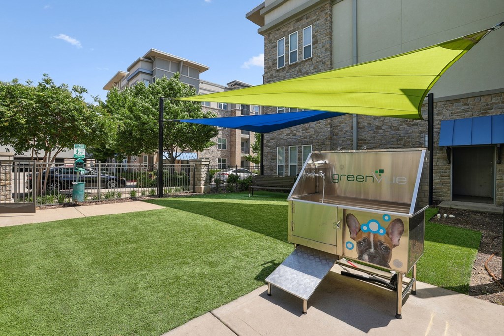 Bark park with shaded area and a pet wash station at GreenVue apartments in Richardson, TX