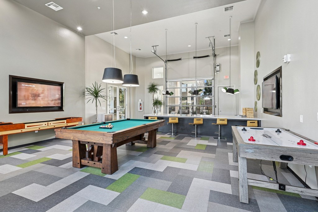 Game room with pool table and air hockey at GreenVue apartments in Richardson, TX