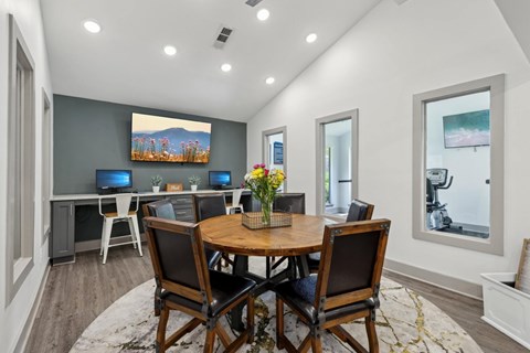 A business center with a wooden table and chairs and computers at Gwinnett Square Apartments in Duluth, GA