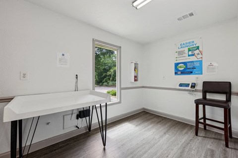 A laundry room with a folding counter at Gwinnett Square Apartments in Duluth, GA