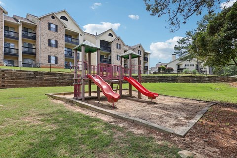 A red playground with slides at Gwinnett Square Apartments in Duluth, GA