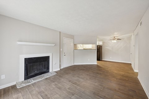 A living room with a fireplace and wood flooring at Gwinnett Square Apartments in Duluth, GA