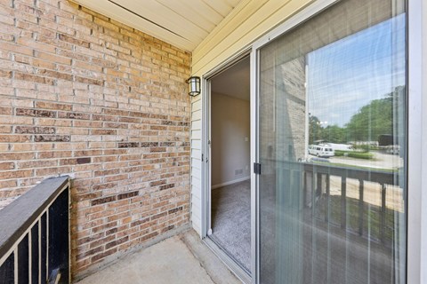 A balcony with a glass door at Gwinnett Square Apartments in Duluth, GA
