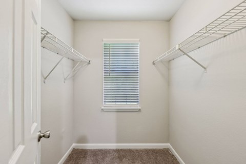 A white closet with a window and a carpeted floor at Gwinnett Square Apartments in Duluth, GA