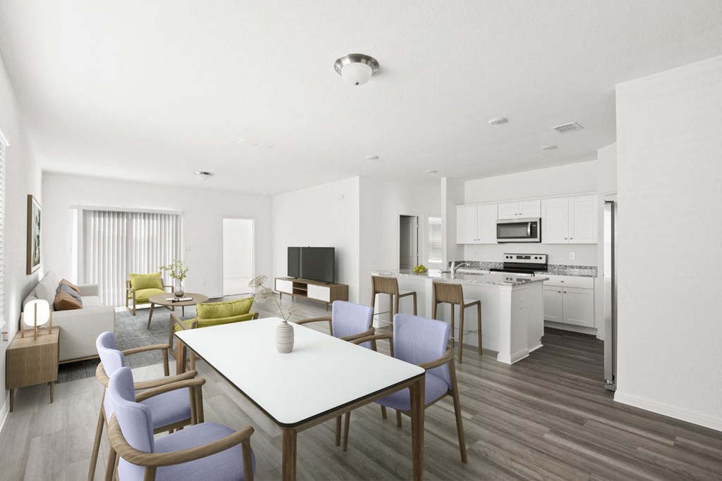 a living room and kitchen with dining tables and chairs