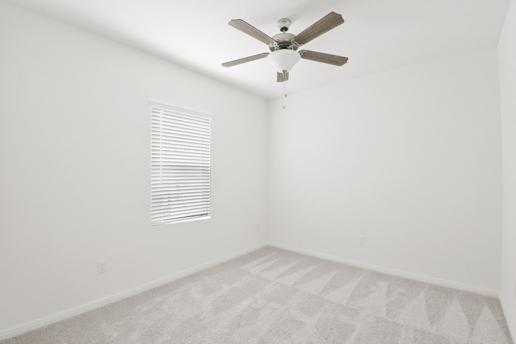 a bedroom with white walls and a ceiling fan at Beacon at Meridian, San Antonio, 78245