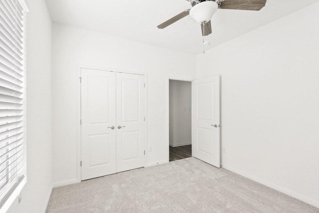 a bedroom with two closets and a ceiling fan at Beacon at Meridian, San Antonio