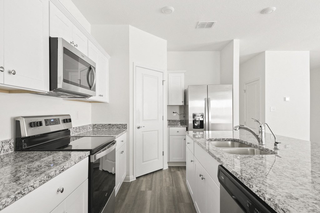 a kitchen with white cabinets and black appliances at Beacon at Meridian, Texas, 78245