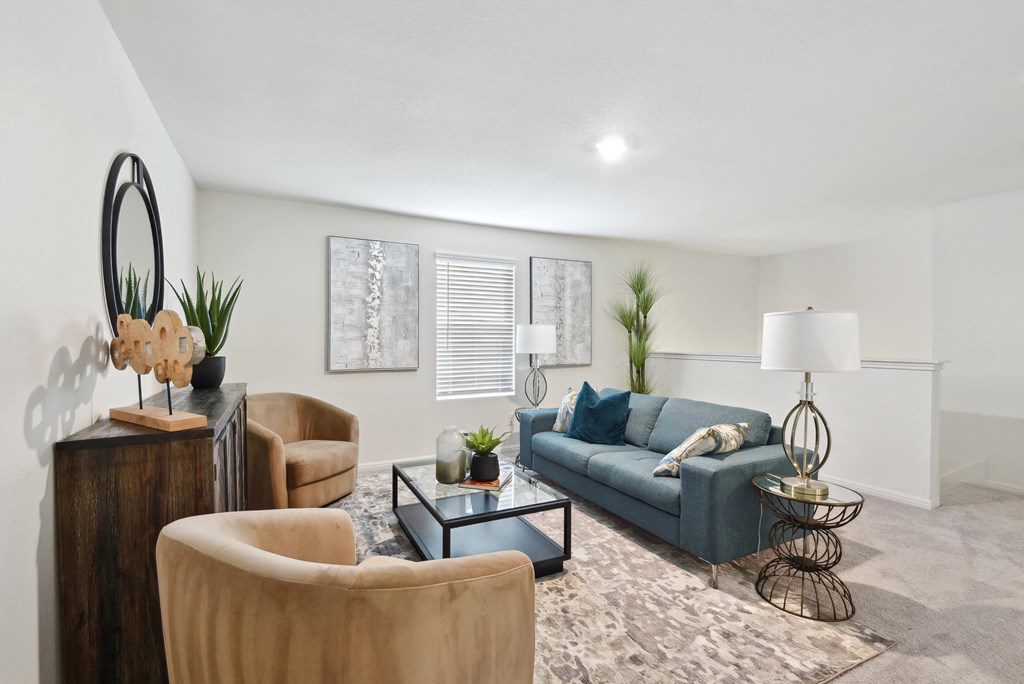 a living room with a blue couch and two chairs