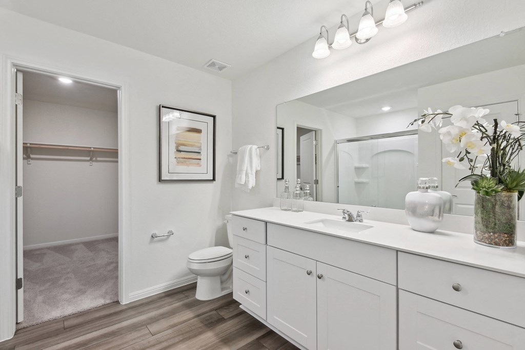 a bathroom with white cabinets and a white toilet