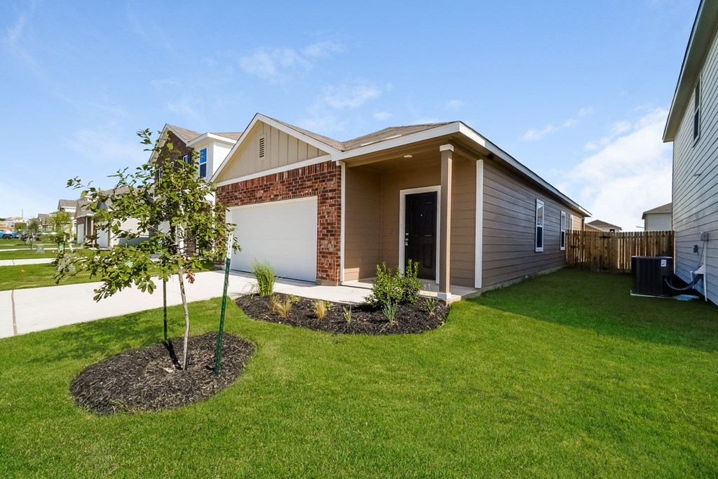 a home with a tree in the front yard at Beacon at Meridian, Texas, 78245