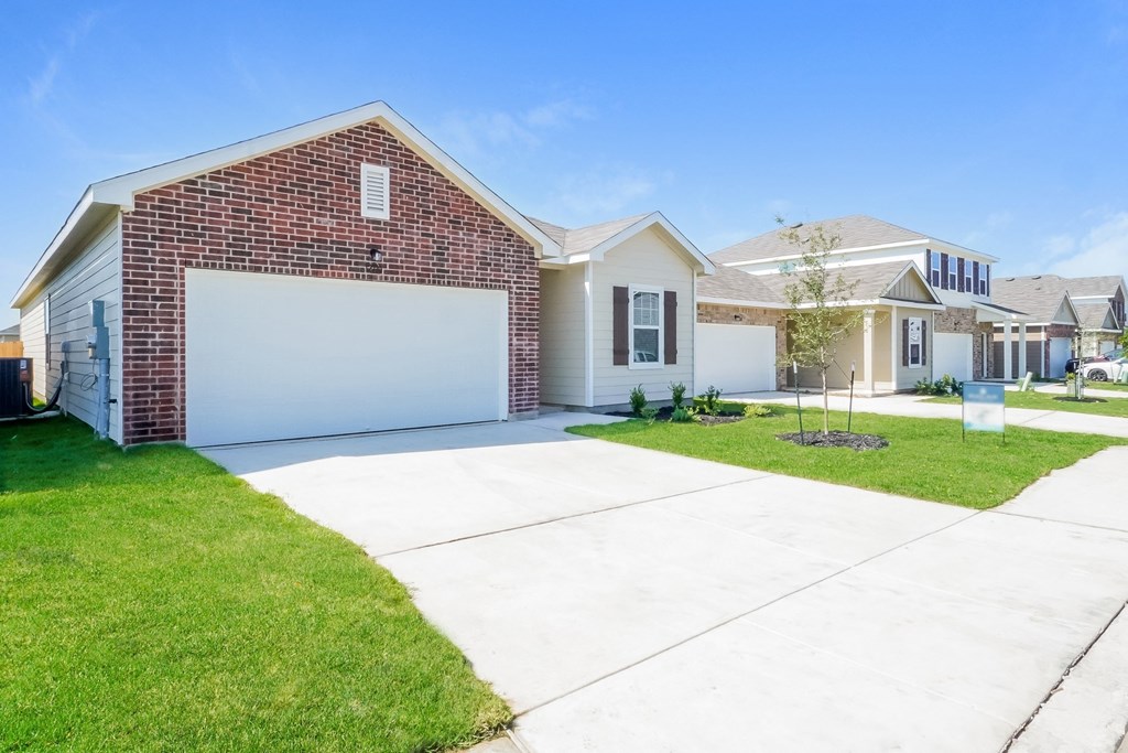 a house with a white garage door and a green lawn at Beacon at Meridian, San Antonio, 78245