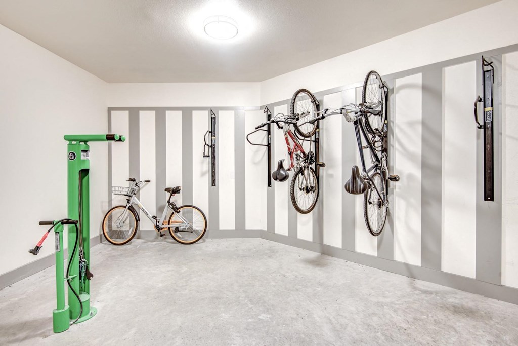 two bikes hanging on the wall in a room with white walls