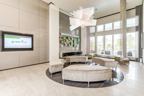 a lobby with couches and chairs and a tv