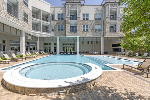 a large swimming pool in front of an apartment building