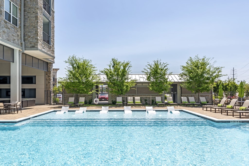 a swimming pool with lounge chairs of GreenVue in Richardson, TX