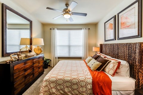 a bedroom with a large bed and a ceiling fan