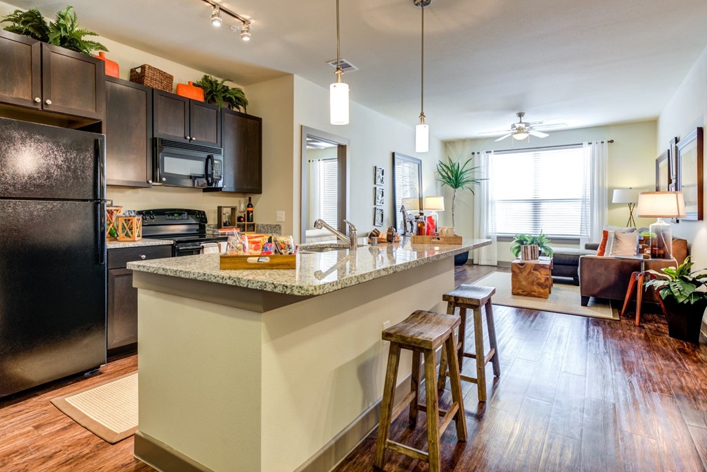 an open kitchen with a large island with bar stools