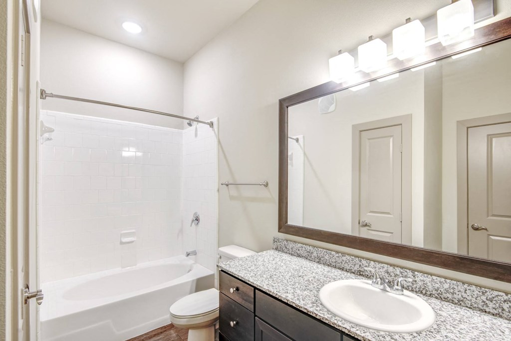 a bathroom with a shower and a sink and a mirror