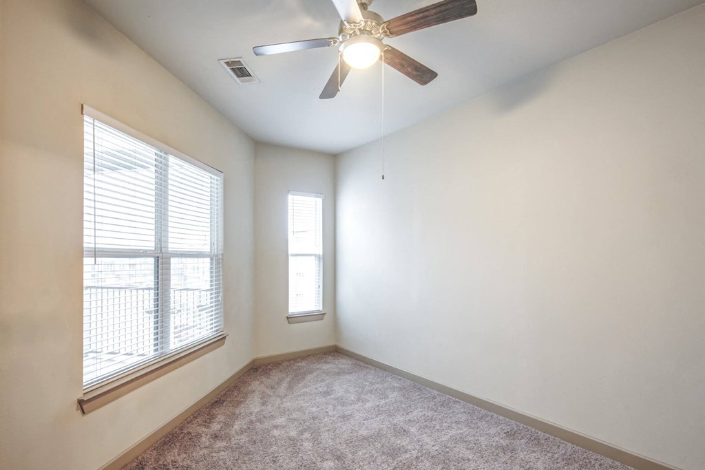 a living room with a large window and a ceiling fan