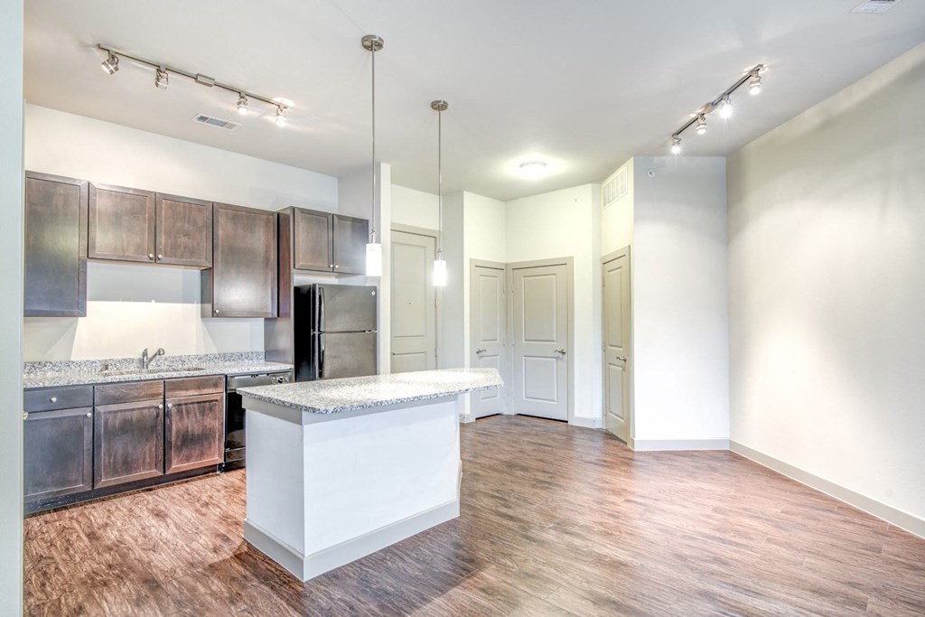 an open kitchen and living room with a large island and wood flooring