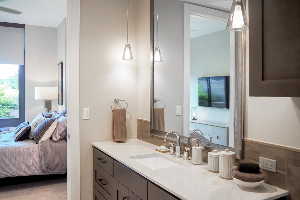 3 bedroom model private bathroom for third bedroom with a sink and a mirror at The Hamilton apartments in Dallas, TX