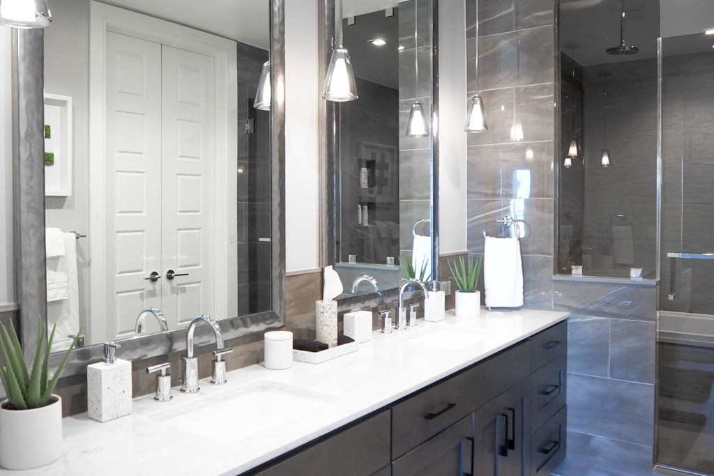 3 bedroom model master bathroom with two sinks and a walk-in shower