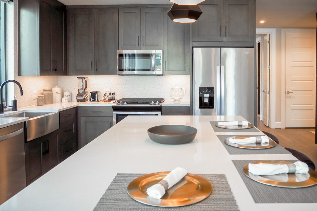 3 bedroom model kitchen with a white quartz counter top and a stainless steel appliances at The Hamilton apartments in Dallas, TX