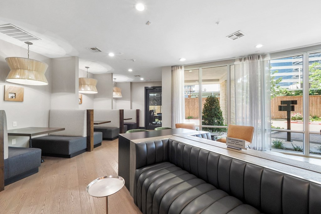 a room with couches and tables in front of a large window