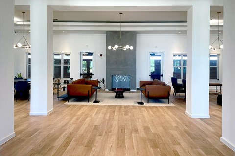 A spacious room with wooden floors and a fireplace.