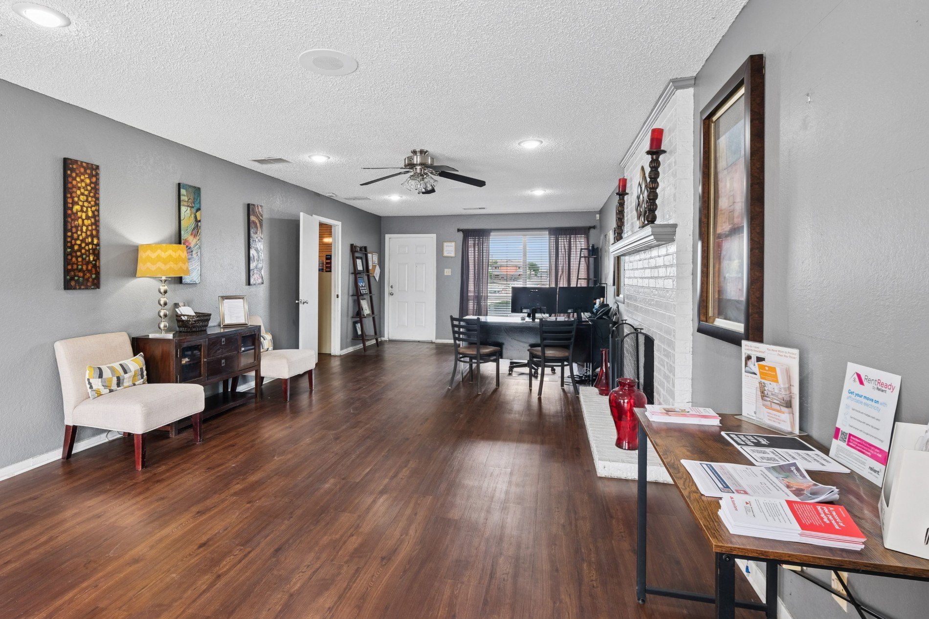 A living room with a white chair and a wooden floor.