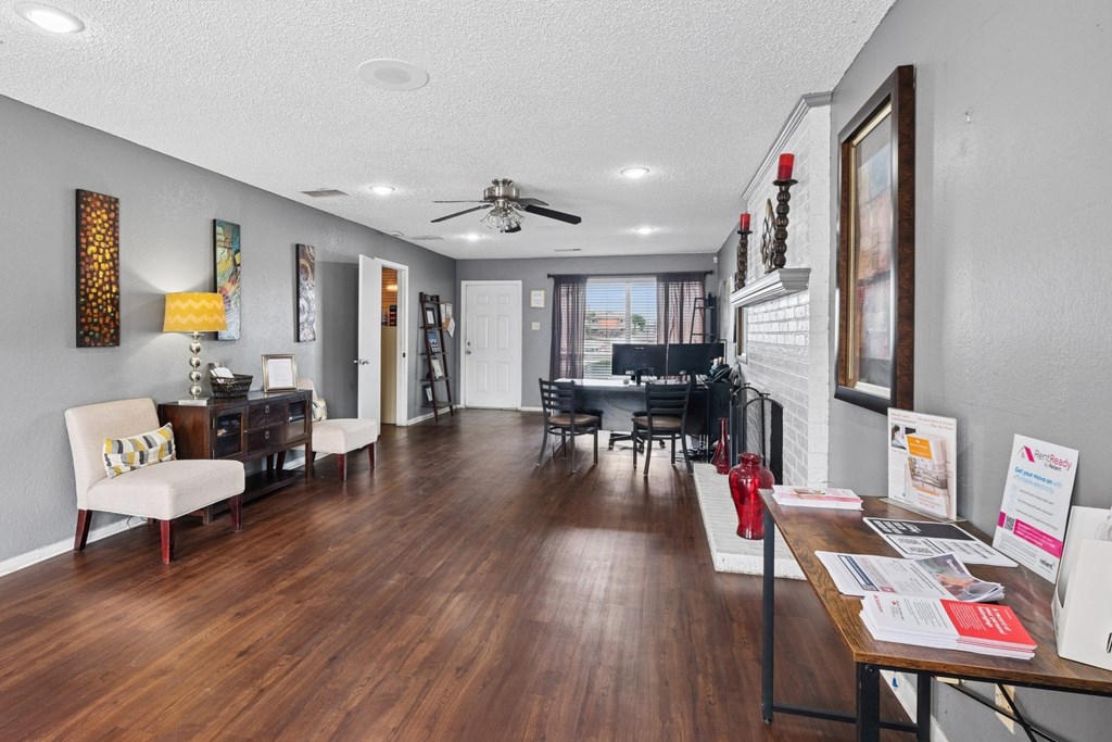 Leasing office with a white chair and a wooden floor at Heritage Square Apartments in Waco, TX