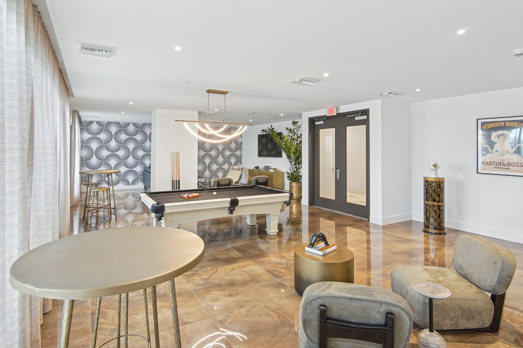 A pool table in our social club with plush seating and a table at Hollywood Heights on the Boulevard Luxury Apartments in Hollywood, FL