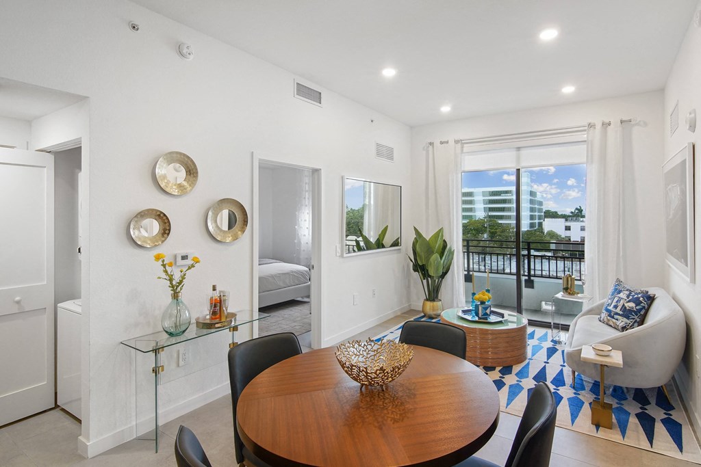 Living room and dining table in our 2-bedroom model with a dining table and chairs  Balcony view of Hollywood Boulevard at Hollywood Heights on the Boulevard Luxury Apartments in Hollywood, FL