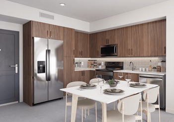 Cozy kitchen area with a dining table, stainless steel appliances and sleek wood cabinets at Hollywood Heights on the Boulevard in Hollywood, FL