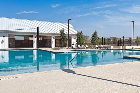 The neighborhood's large outdoor swimming pool with a pavilion in the background at Beacon at Hymeadow in Maxwell, TX.
