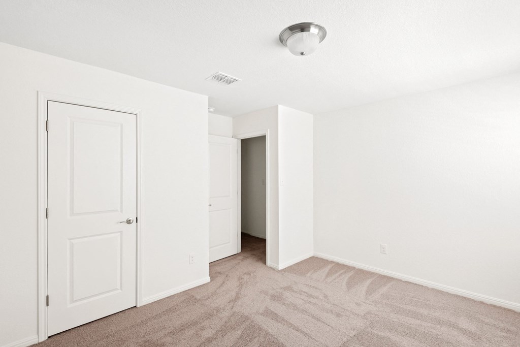 a bedroom with white walls and carpet