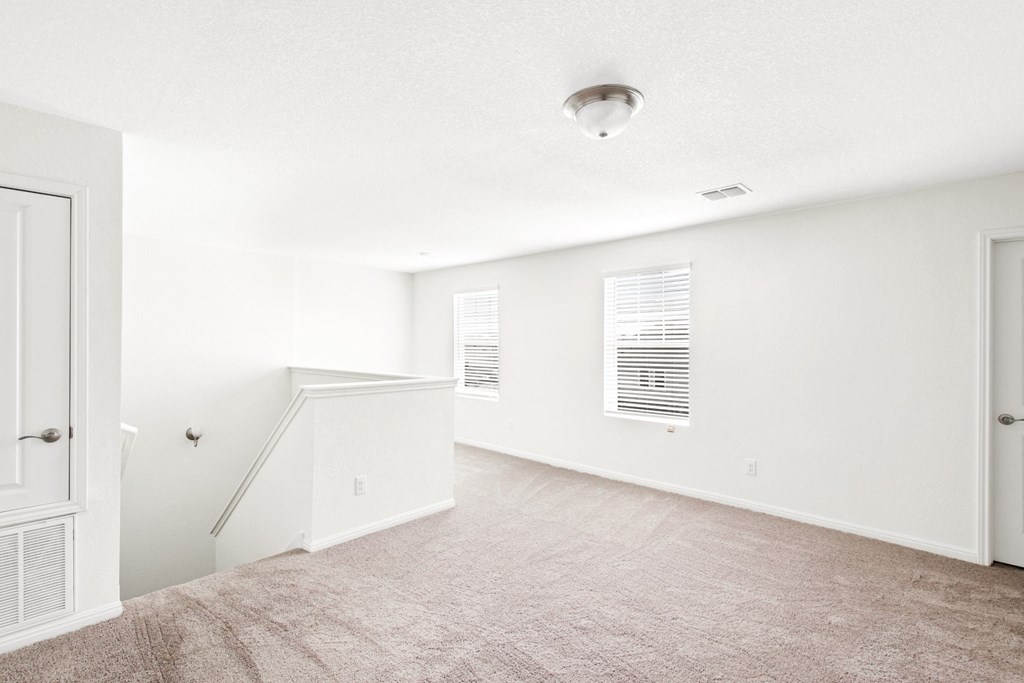 the loft bedroom with white walls and carpet